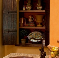 An arched wall niche with old wood doors and antique hinges.